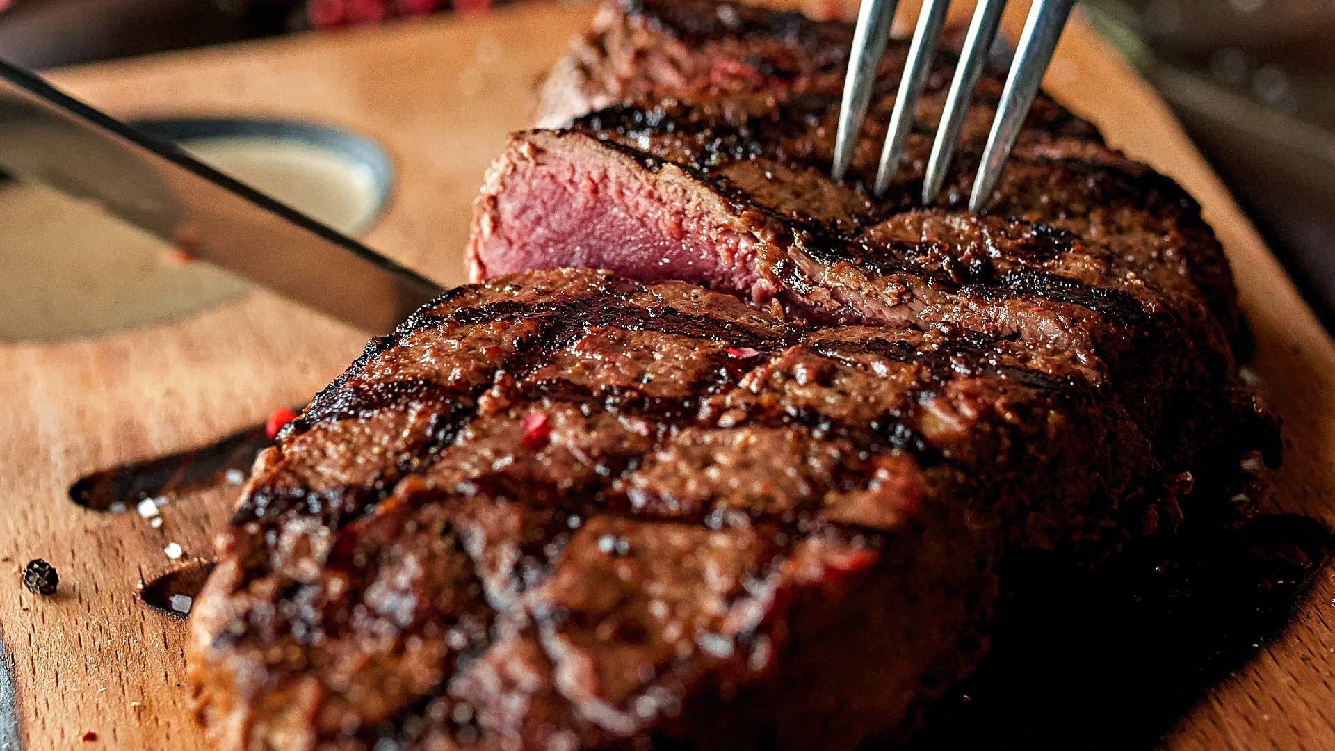 Steak grilled medium being cut into